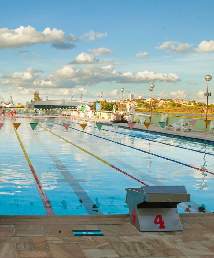 Piscina com raia do Clube Jaraguá com área esportiva.